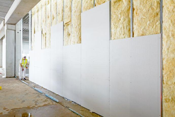 Man bekleedt muur in een huis met dikke isolatie waardoor luchtbehandeling nodig is om condensatie te vermijden